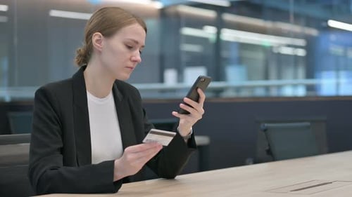 Woman Uses Credit Card and Smartphone in Office
