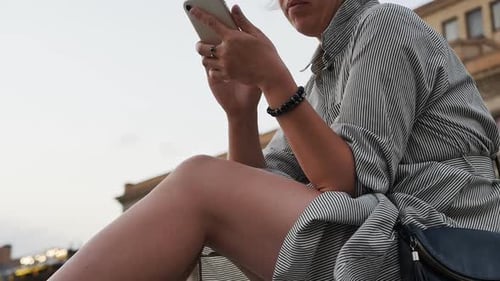 Woman Uses Phone Outdoors in the City
