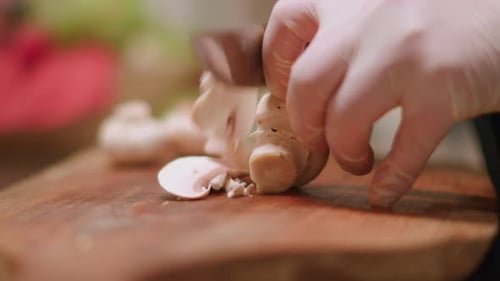 Close up of Mushrooms Being Sliced on Wooden Board