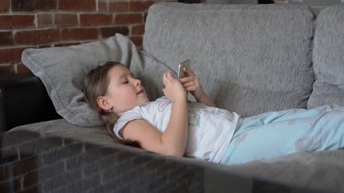 Girl Lying on Couch Using Mobile Phone