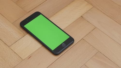 ZAJECAR, SERBIA - NOVEMBER 2016 Tilting on green screen chroma key display of black phone on wooden