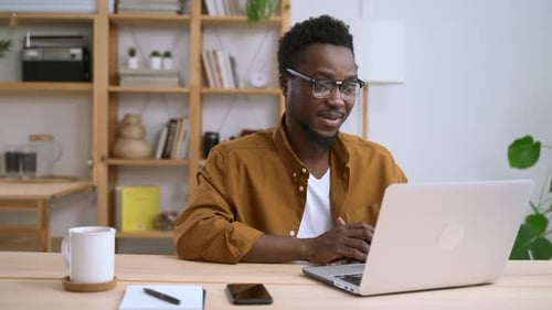 Adult Man Works at Laptop in Home Office