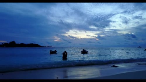 Family of two tan on marine coast beach journey by turquoise ocean and white sandy background of the