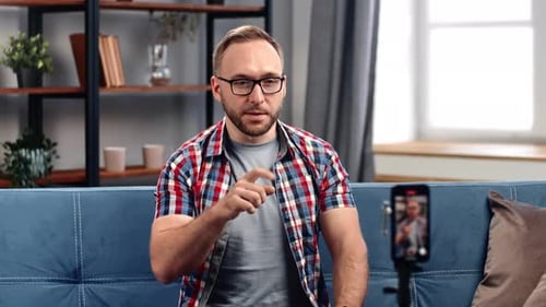 Man Talking into Smartphone Camera on Tripod Indoors