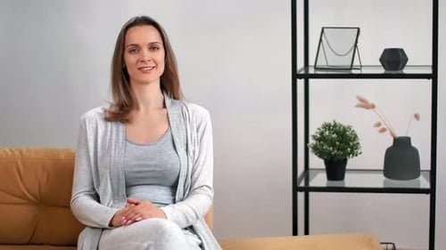 Woman Sits and Smiles in Living Room