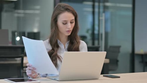 Stressed Woman Working with Documents in Office