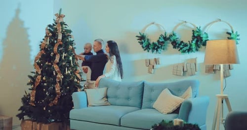 Family Decorates Christmas Tree in Living Room