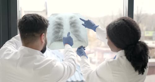 Doctor and Coworker Standing and Looking at Xrays in Clinic