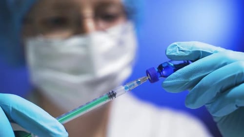 Doctor's Hands Hold Syringe and Tube with Vaccine at Hospital