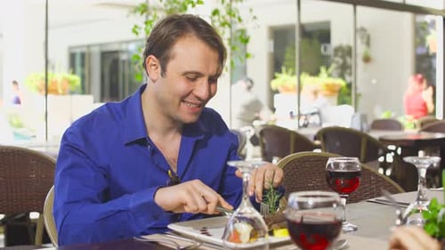 The couple drinks wine and eats.