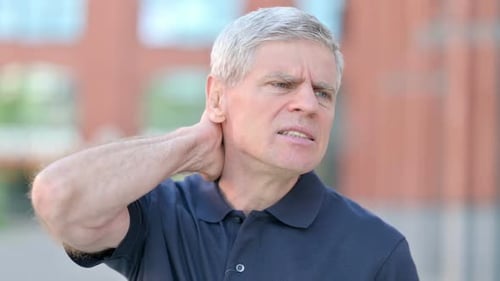 Man Rubs Sore Neck, Gray Hair, Urban Environment