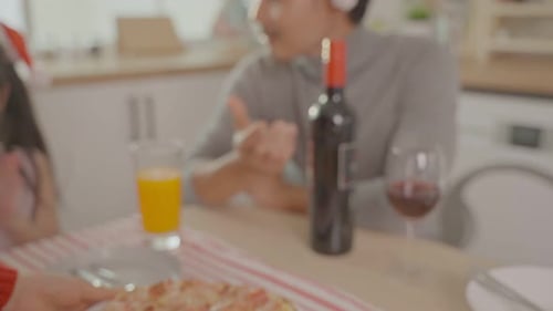 Family Enjoys Pizza During Christmas Celebration Indoors