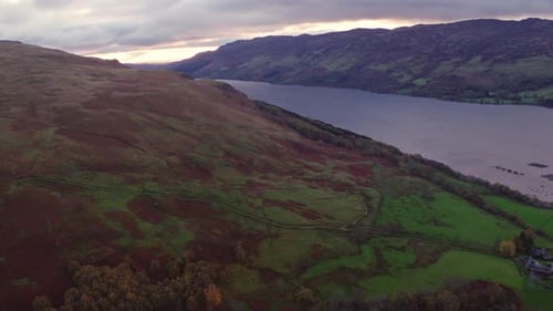 Flying Over a Mountain Slope with a View of the Loch in Between Mountain Ranges