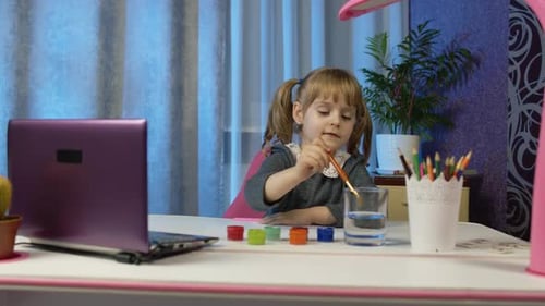 Little Girl Painting with Brush in her Home