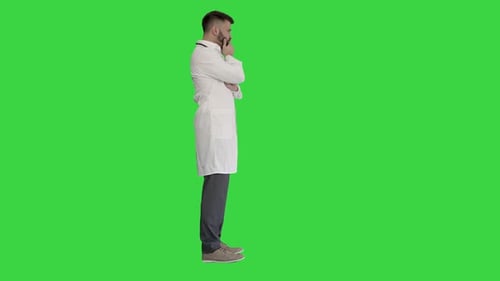 Doctor Standing and Thinking Hard on a Green Screen, Chroma Key.