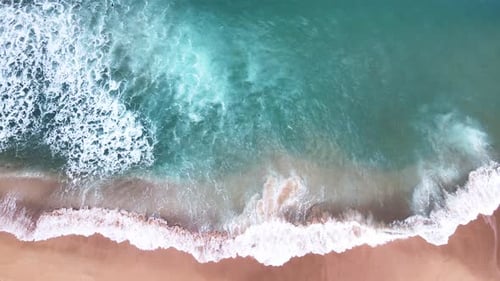 Aerial Top View of Ocean Waves Reaching Beach Shore. Drone Footage.