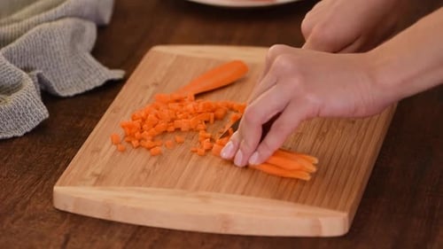 Hands Dicing Carrots on Cutting Board