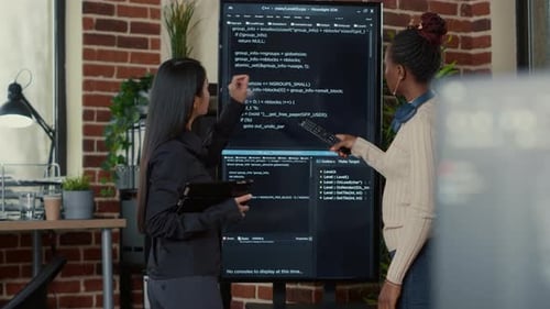 Team of Programmers Analyzing Code on Wall Screen Tv Looking for Bugs and Errors