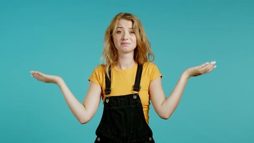 Unsure Woman in Overall Shrugs Her Arms, Makes Gesture of I Don't Know, Care, Can't Help Anything
