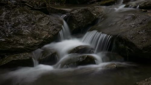 A Small Wild Stream Flows Over Rocks in