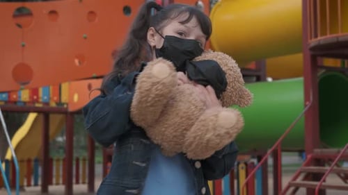 Happy child in a mask on the playground.