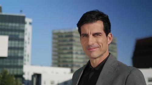 Homme d'affaires posant devant la caméra dans la rue. Beau cadre debout à l'extérieur