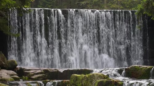 Picturesque Waterfall Cascades Down Rocky Dam in Forest