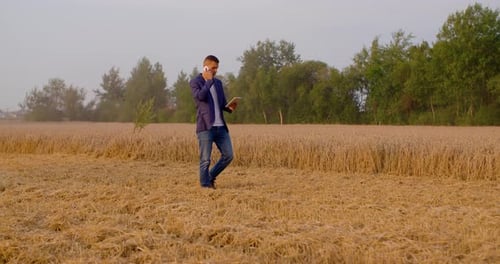 Agricultura - Agricultor usando tablet digital durante a colheita