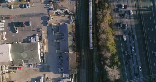 Ein Zug und der Verkehr, der sich entlang paralleler Linien bewegt, aus der Vogelperspektive
