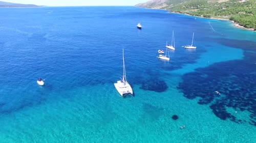 Aerial view of sailing boats and an expensive yacht mooring