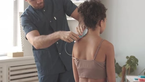 Doctor Attaches Medical Sensors to Child in Office