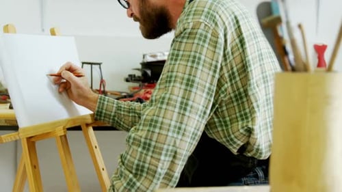 Artist Sketching on Canvas in Studio