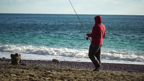 Mann, Hobby, Angeln auf See, zieht eine Angelschnur fest, eine Angelrolle, im Sommer