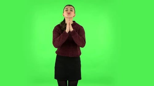 Mädchen hält die Handfläche zusammen und bittet um etwas. Greenscreen