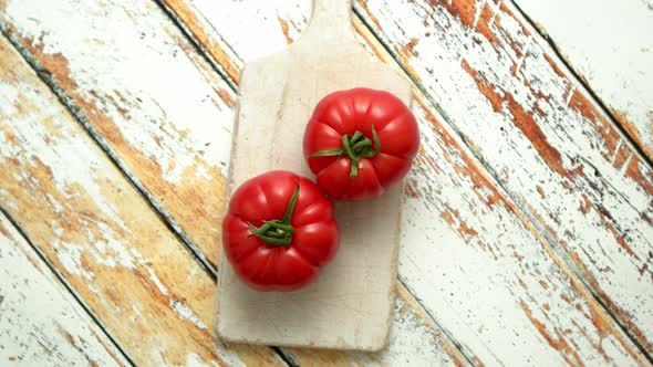 Cover for Two Fresh Eco Tomatoes Placed on White Wooden Cutting Board