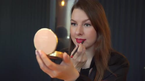 Woman Applying Red Lipstick in Mirror