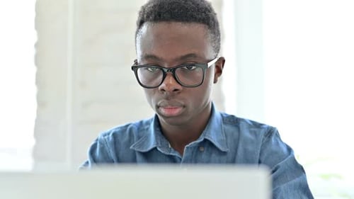 Young Adult Working on Laptop Indoors Close Up
