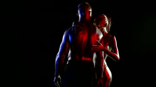 Passionate Couple Embrace in Dark, Intimate Setting