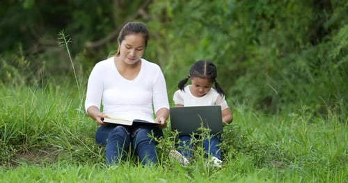 Woman and Child Learning Together Outdoors