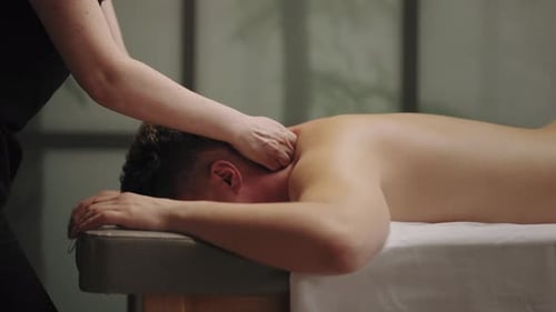 Entspannungsmassage zur Heilung von Nacken- und Kopfschmerzen Professionelle Masseuse massiert den männlichen Körper