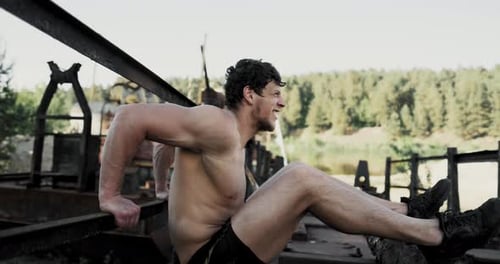 Muscular Man Does Tricep Dips Outside