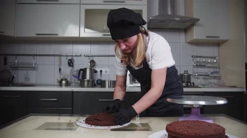 Woman Prepares Chocolate Cake Layer in Kitchen