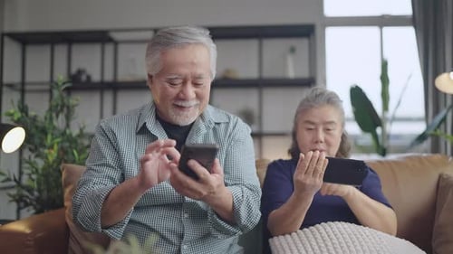 Senior Couple Relaxing at Home with Smartphones