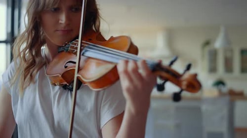 Young Woman Plays Violin in Home Interior