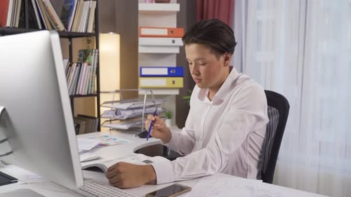 Young Adult Working at a Computer and Studying