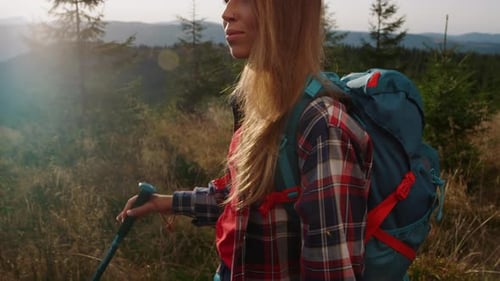 Woman Hiking Mountain with Backpack and Trekking Poles