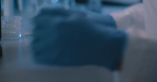 Scientist Adding Liquid to Petri Dish in Lab