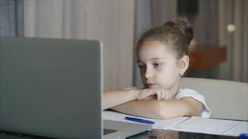 The Younger Student Sits at Home at the Computer, Studies, Listens To School Lectures, and Does His