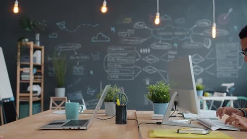 Young People Man and Woman Working in Office Using Computers and Talking Sharing Ideas