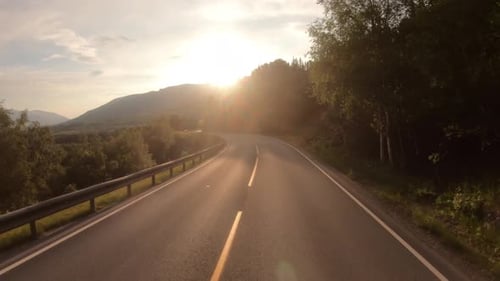 Driving a Car on a Road in Norway at Dawn